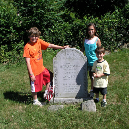Bernard J. Stanton kneeling beside the gravestone marker he designed